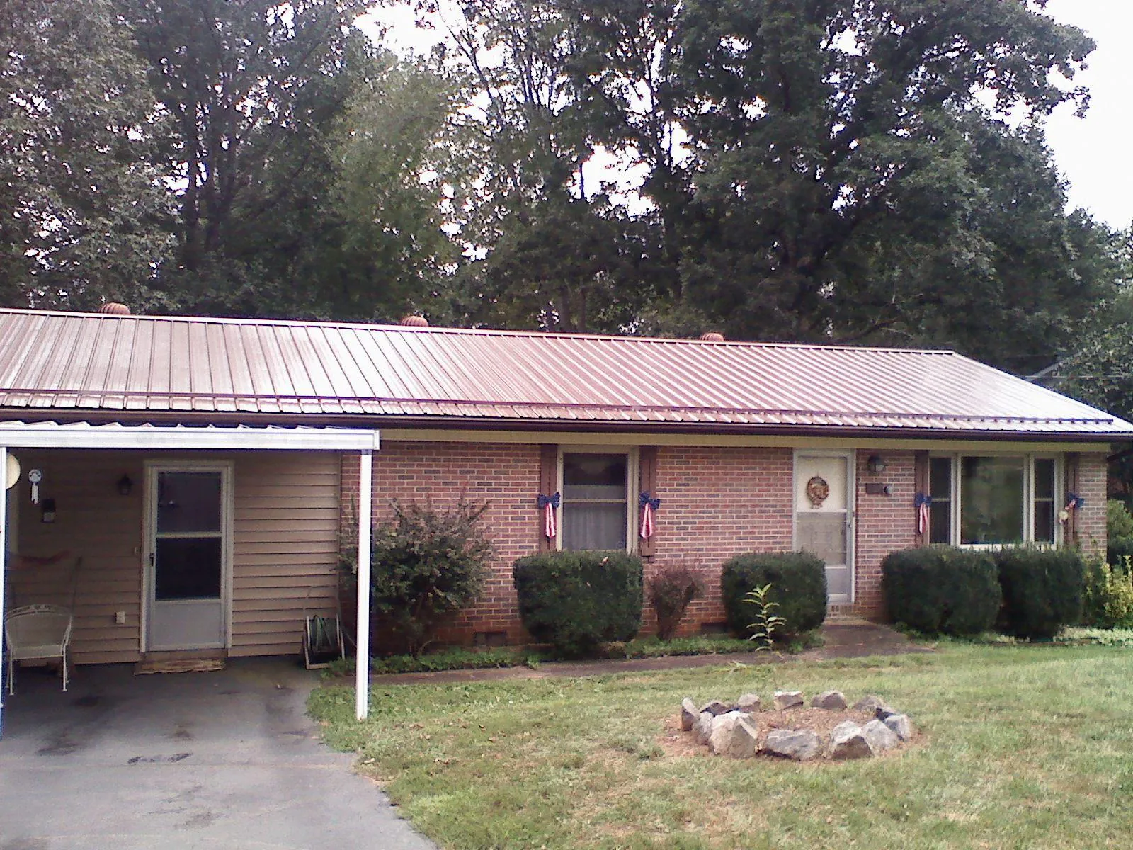 Bronze metal roof and carport on a brick ranch home — Roof Repair work by our crew in Wadsworth